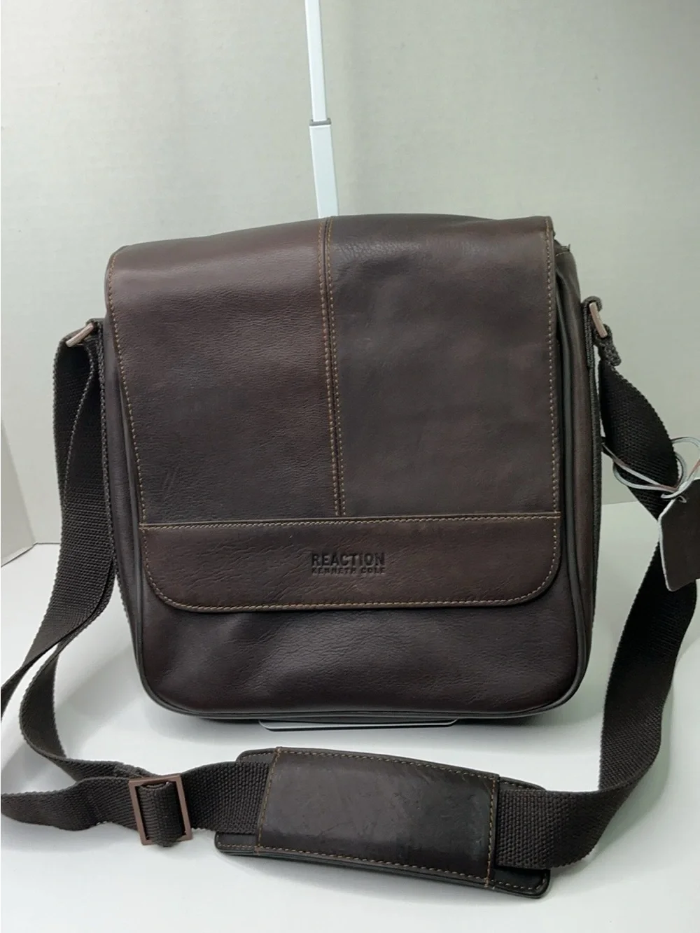 Kenneth Cole Reaction dark brown leather messenger-style tablet bag.